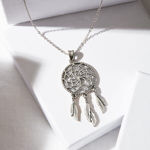 A dreamcatcher pendant with sterling silver chain placed on a soul analyse pendant box