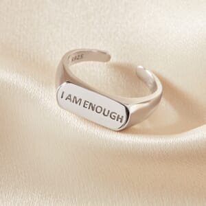 I am enough sterling silver signet ring on a cream sheet