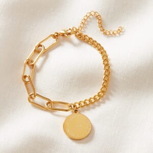 I AM dual gold chain stainless steel bracelet resting on a cream cloth