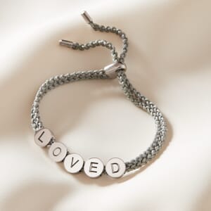 loved bead silver rope bracelet lying on a cream sheet