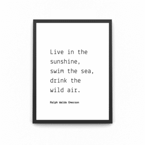 A wooden A4 black frame with the quote saying ' live in the sunshine, swim in the sea drink in the wild air' quoted by Ralph waldo emerson