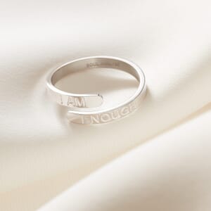 i am enough silver stainless steel adjustable ring placed on a cream cloth