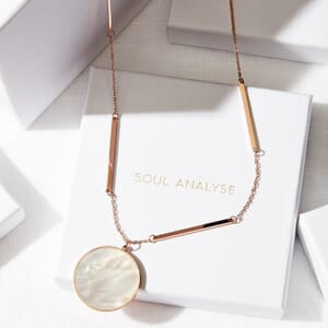a rose gold shell coin necklace placed on a soul analyse pendant box