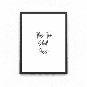 A wooden A4 black frame with the quote saying ' this too shall pass'