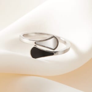 Yin Yang silver stainless steel adjustable ring sitting on a cream sheet