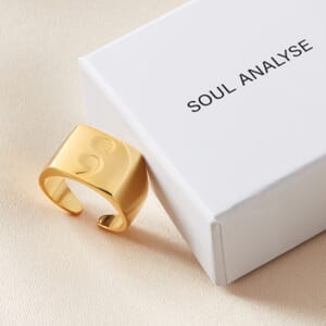 semi colon gold plated sterling silver square signet ring placed alongside a soul analyse ring box