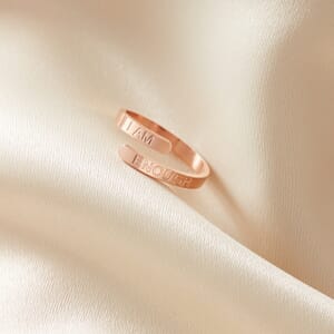 i am enough rose gold stainless steel adjustable ring placed on a cream cloth
