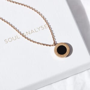 'you are loved' white and black shell inlay rose gold necklace placed on a pendant box